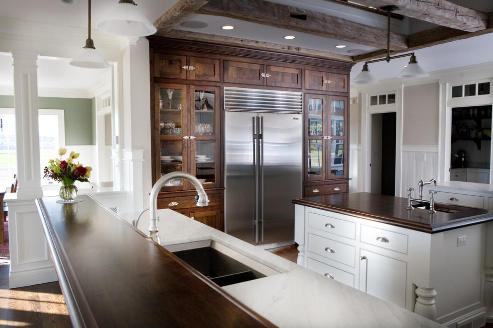 Ejemplo de cocina clásica con fregadero bajoencimera, puertas de armario de madera en tonos medios y armarios con paneles empotrados