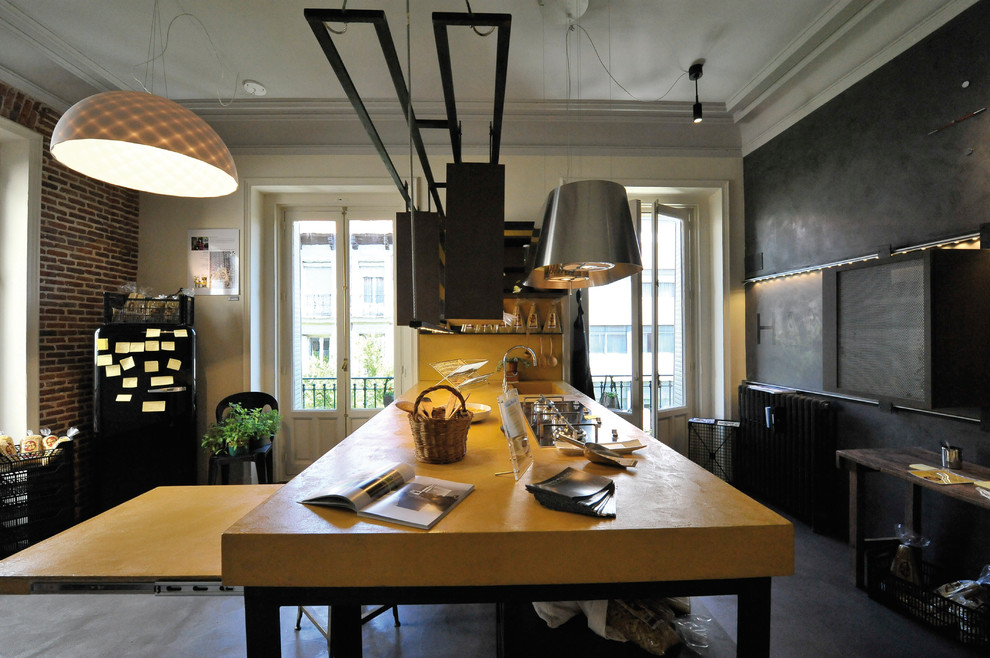 На фото: прямая кухня-гостиная среднего размера в стиле лофт с открытыми фасадами, темными деревянными фасадами, столешницей из известняка, техникой из нержавеющей стали, бетонным полом, островом и желтым фартуком с
