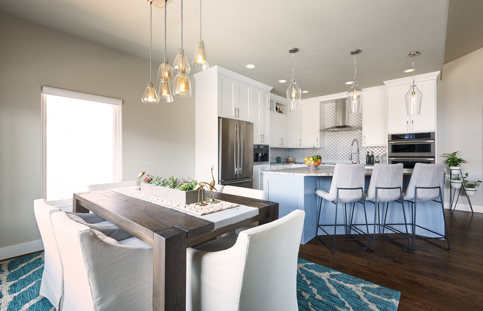 Inspiration for a mid-sized contemporary l-shaped dark wood floor and brown floor open concept kitchen remodel in Denver with a single-bowl sink, shaker cabinets, white cabinets, granite countertops, white backsplash, ceramic backsplash, stainless steel appliances, an island and gray countertops