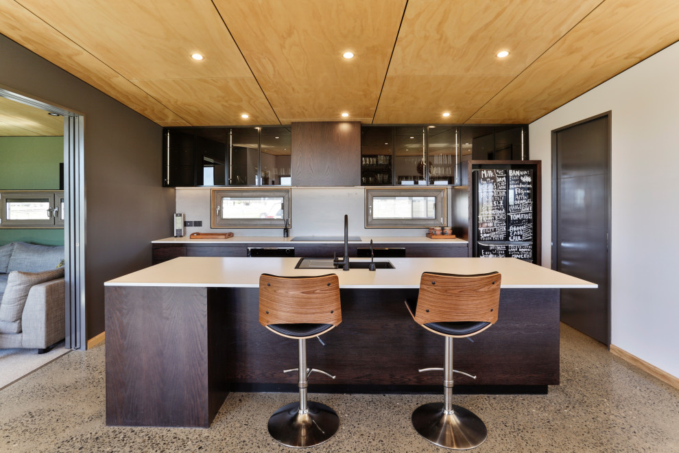Enclosed kitchen - mid-sized contemporary single-wall terrazzo floor, multicolored floor and wood ceiling enclosed kitchen idea in Christchurch with an undermount sink, quartz countertops, black appliances, an island, white countertops, glass-front cabinets and white backsplash