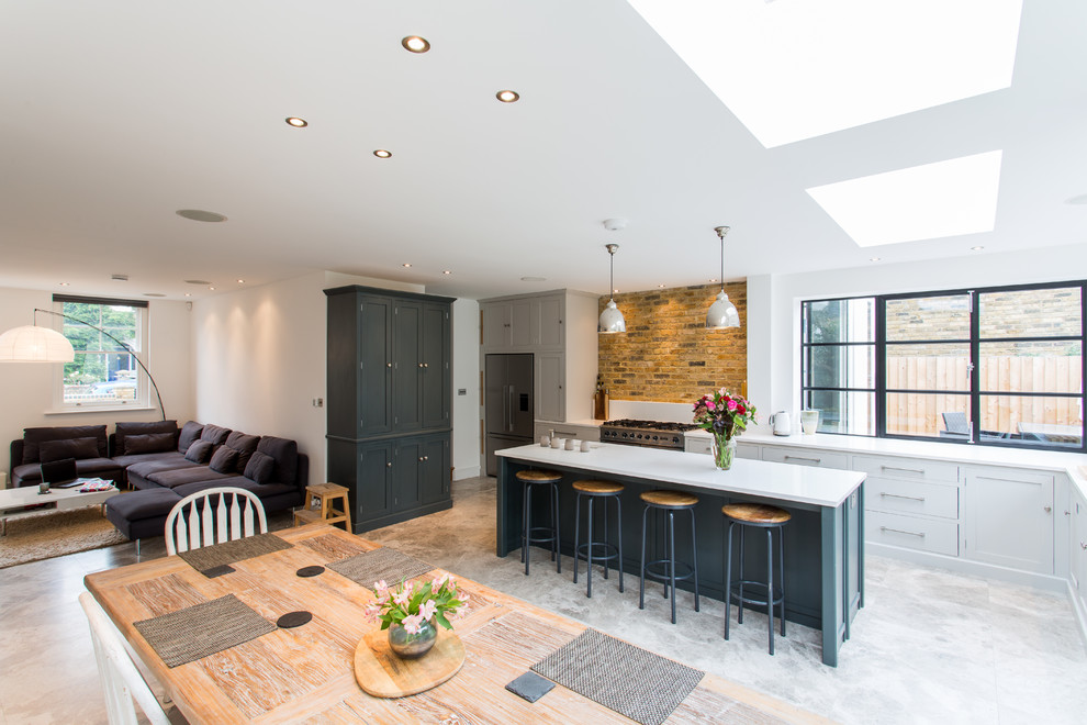 Große Moderne Wohnküche in L-Form mit integriertem Waschbecken, Schrankfronten im Shaker-Stil, grauen Schränken, Mineralwerkstoff-Arbeitsplatte, Terrazzo-Boden und Kücheninsel in Surrey