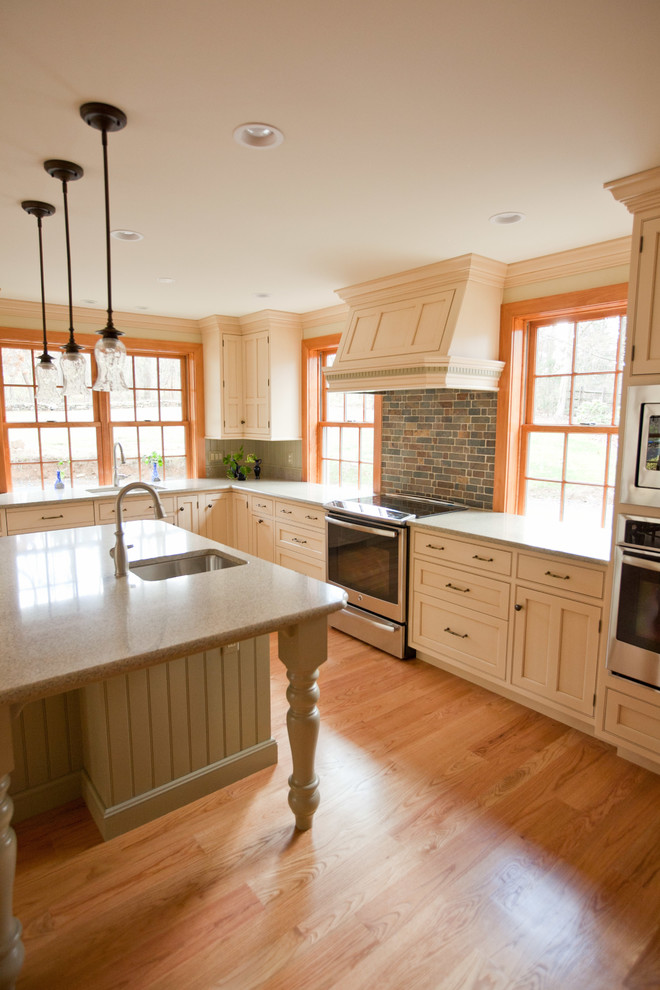 Foto på ett stort vintage brun l-kök, med en undermonterad diskho, skåp i shakerstil, beige skåp, bänkskiva i koppar, flerfärgad stänkskydd, stänkskydd i stenkakel, rostfria vitvaror, ljust trägolv, en köksö och beiget golv