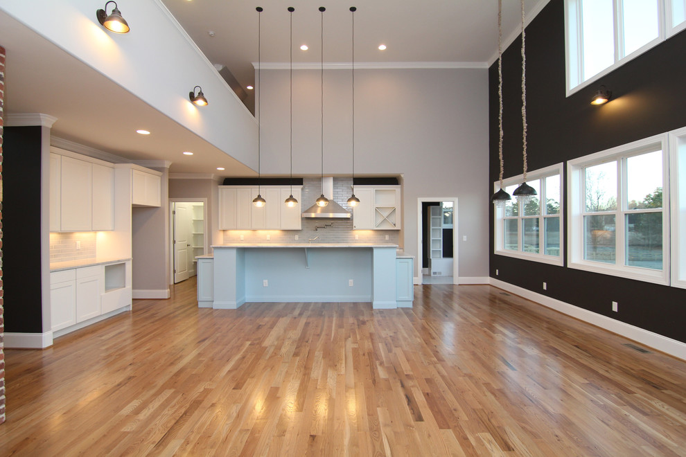 This is an example of a large contemporary kitchen in Raleigh with light hardwood flooring.
