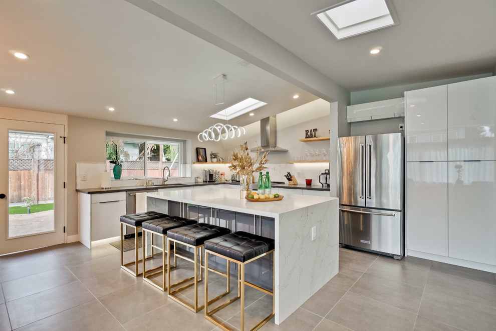 Foto di una cucina minimal con lavello sottopiano, ante lisce, ante bianche, paraspruzzi bianco, elettrodomestici in acciaio inossidabile, pavimento grigio e top bianco