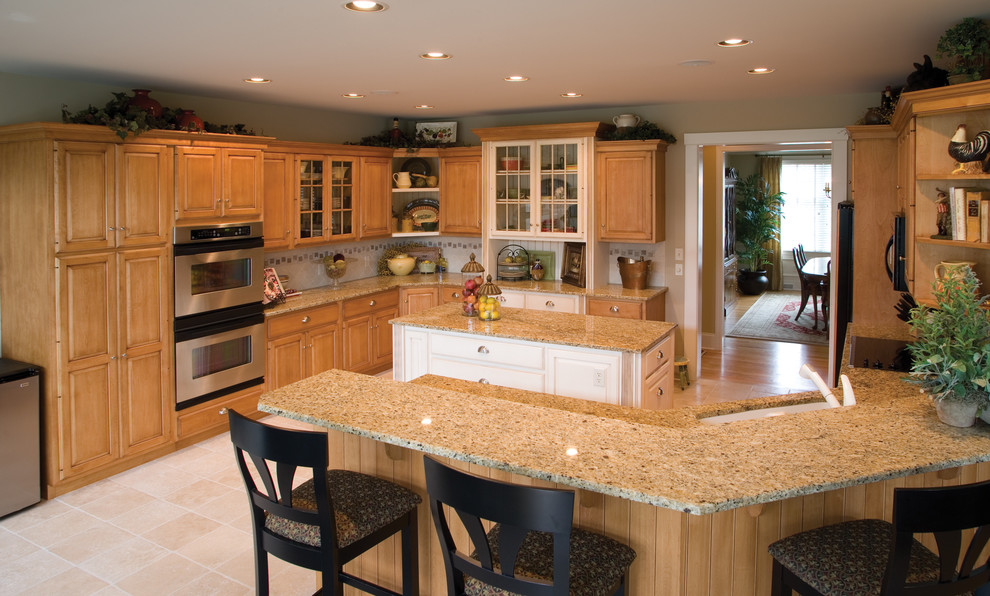 Example of a porcelain tile eat-in kitchen design in Philadelphia with an undermount sink, raised-panel cabinets, light wood cabinets, quartz countertops, ceramic backsplash and stainless steel appliances