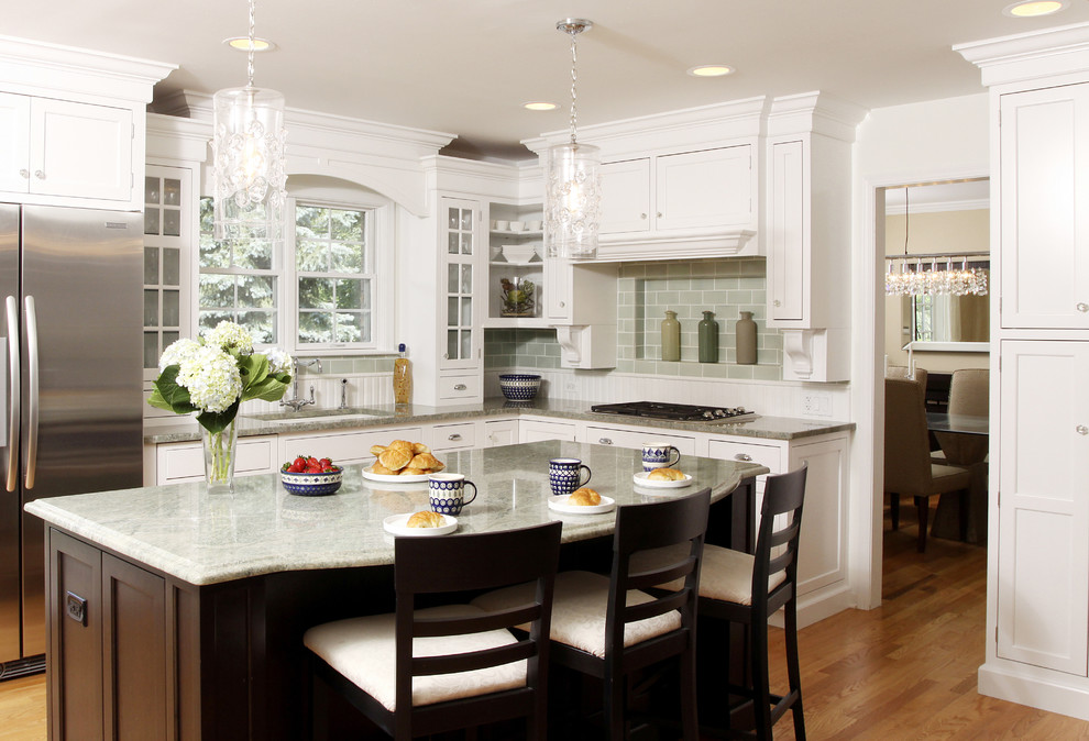 Enclosed kitchen - large traditional l-shaped medium tone wood floor enclosed kitchen idea in Chicago with an undermount sink, shaker cabinets, white cabinets, granite countertops, green backsplash, subway tile backsplash, stainless steel appliances and an island