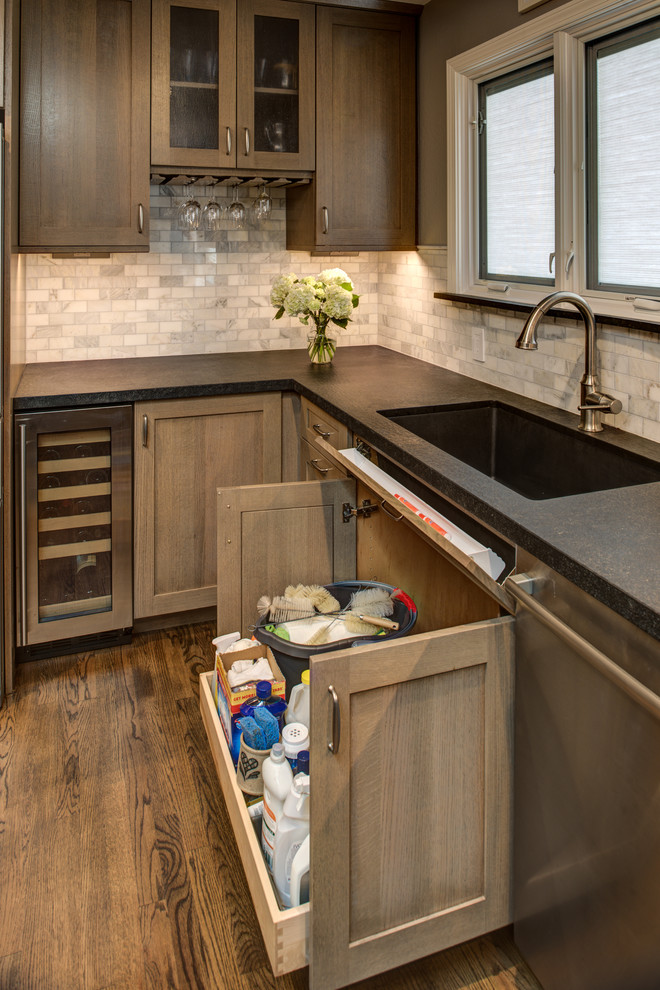 Foto på ett avskilt, mellanstort amerikanskt l-kök, med en undermonterad diskho, skåp i shakerstil, skåp i mellenmörkt trä, granitbänkskiva, stänkskydd i stenkakel, rostfria vitvaror och mörkt trägolv
