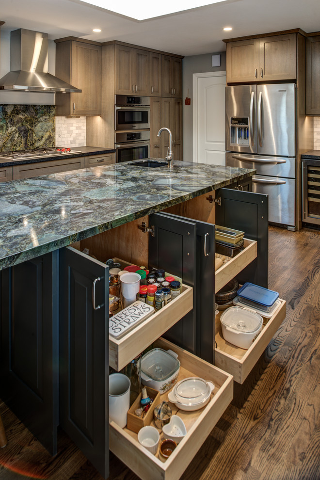 Inspiration for a mid-sized craftsman u-shaped light wood floor enclosed kitchen remodel in San Francisco with an undermount sink, shaker cabinets, medium tone wood cabinets, granite countertops, gray backsplash, stone tile backsplash, stainless steel appliances and an island
