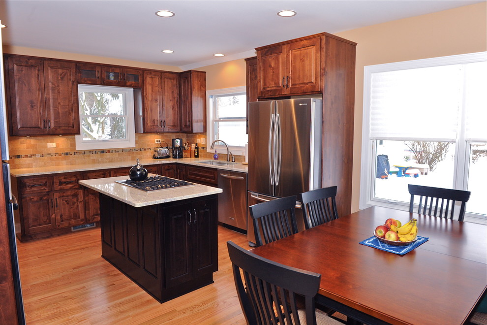 Modern inredning av ett mellanstort kök, med en dubbel diskho, luckor med upphöjd panel, skåp i mellenmörkt trä, granitbänkskiva, flerfärgad stänkskydd, stänkskydd i stenkakel, rostfria vitvaror, ljust trägolv och en köksö