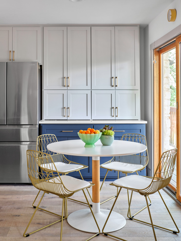 Foto di una grande cucina classica con ante in stile shaker, ante blu, top in quarzo composito, paraspruzzi con piastrelle di cemento, elettrodomestici in acciaio inossidabile, parquet chiaro e top bianco
