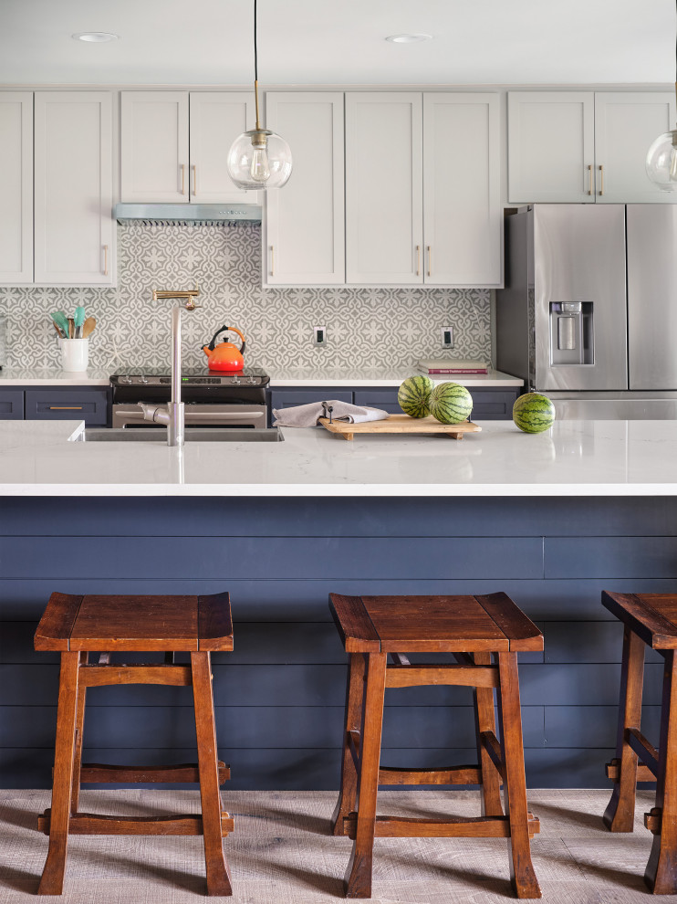 Zweizeilige, Große Klassische Küche mit Schrankfronten im Shaker-Stil, blauen Schränken, Quarzwerkstein-Arbeitsplatte, Rückwand aus Zementfliesen, Küchengeräten aus Edelstahl, hellem Holzboden, Kücheninsel und weißer Arbeitsplatte in Austin