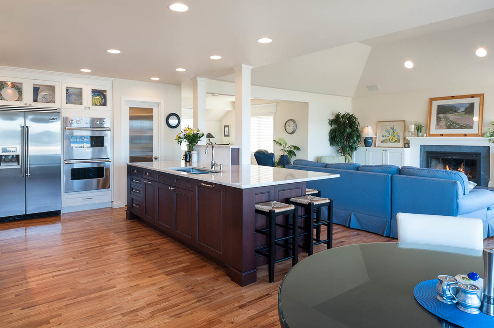 Inspiration for a large craftsman l-shaped light wood floor eat-in kitchen remodel in Seattle with an undermount sink, shaker cabinets, white cabinets, quartz countertops, white backsplash, subway tile backsplash, stainless steel appliances and an island