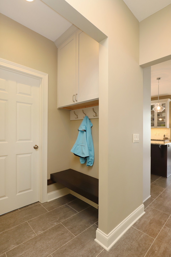 Exempel på ett mellanstort klassiskt kök, med en undermonterad diskho, luckor med infälld panel, vita skåp, granitbänkskiva, vitt stänkskydd, stänkskydd i tunnelbanekakel, rostfria vitvaror, klinkergolv i keramik, en köksö och brunt golv