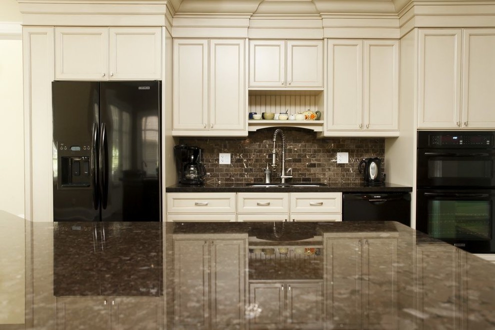 Foto på ett stort funkis kök, med en dubbel diskho, luckor med infälld panel, beige skåp, granitbänkskiva, beige stänkskydd, svarta vitvaror, mellanmörkt trägolv och en köksö