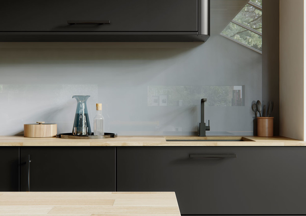 Foto de cocina contemporánea con armarios con paneles lisos, puertas de armario azules, encimera de madera, salpicadero verde, salpicadero de vidrio templado, electrodomésticos negros y una isla