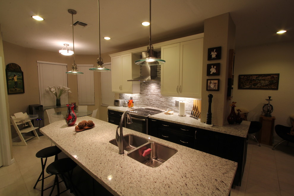 Bild på ett avskilt, mellanstort funkis parallellkök, med en undermonterad diskho, skåp i shakerstil, vita skåp, granitbänkskiva, flerfärgad stänkskydd, stänkskydd i mosaik, rostfria vitvaror och en köksö
