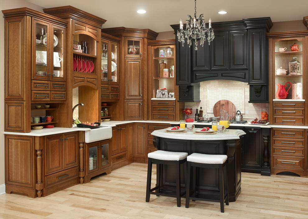 Design ideas for a classic l-shaped kitchen in New York with a belfast sink, raised-panel cabinets, brown cabinets, engineered stone countertops, beige splashback, ceramic splashback, stainless steel appliances, light hardwood flooring and an island.