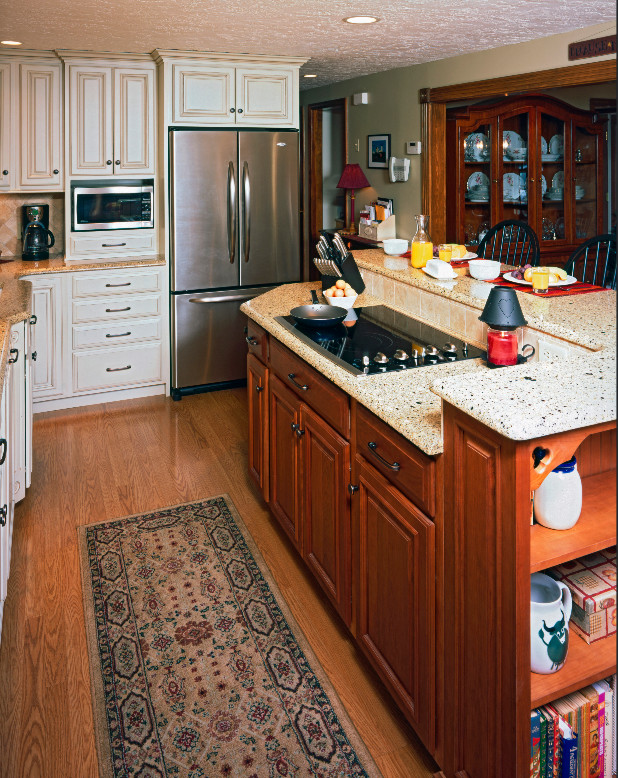 Idéer för att renovera ett vintage l-kök, med en undermonterad diskho, luckor med upphöjd panel, vita skåp, bänkskiva i kvarts, beige stänkskydd, stänkskydd i stenkakel, rostfria vitvaror, mellanmörkt trägolv och brunt golv