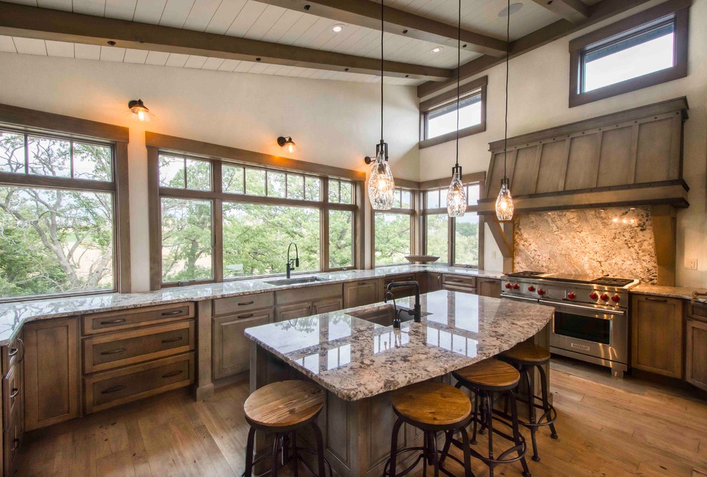 Large mountain style u-shaped medium tone wood floor and brown floor eat-in kitchen photo in Other with an undermount sink, recessed-panel cabinets, distressed cabinets, granite countertops, multicolored backsplash, stone slab backsplash, paneled appliances, an island and multicolored countertops