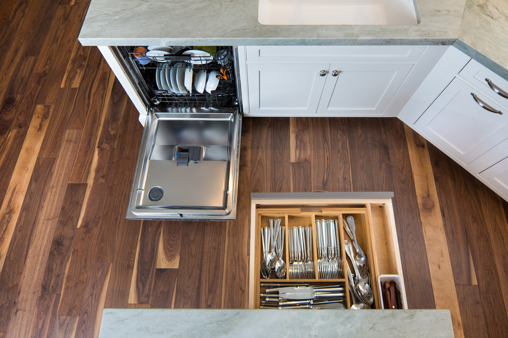 Exempel på ett klassiskt kök, med en undermonterad diskho, luckor med profilerade fronter, vita skåp, bänkskiva i kvartsit, grått stänkskydd, rostfria vitvaror, mellanmörkt trägolv, en köksö och stänkskydd i keramik
