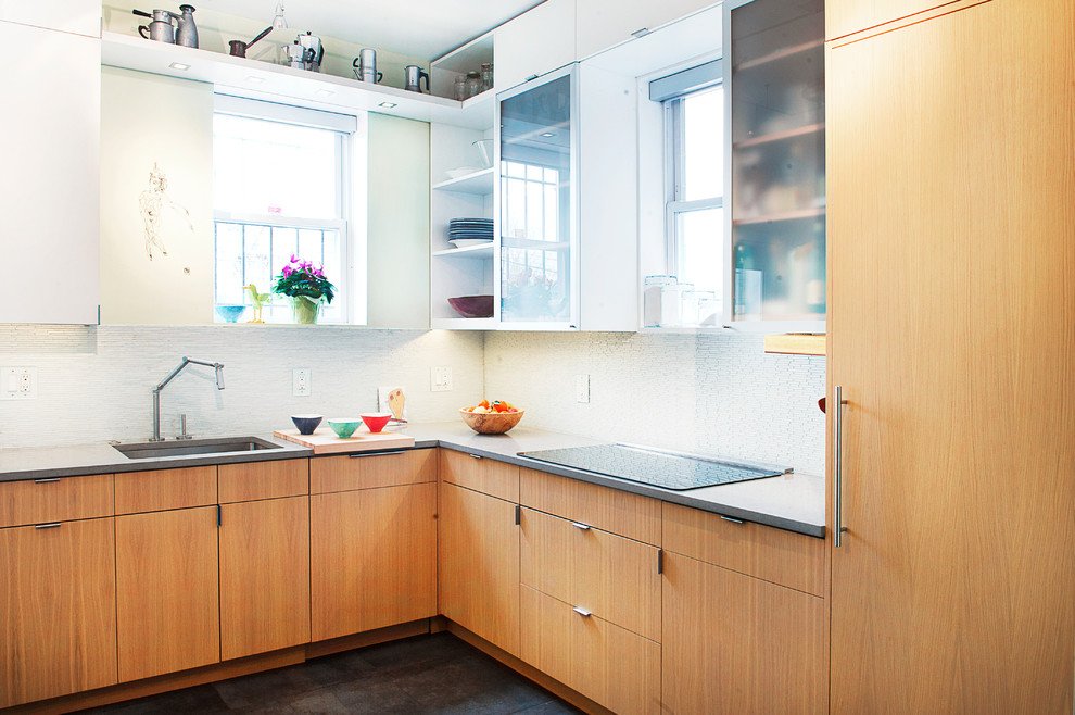 Foto di una cucina a L contemporanea di medie dimensioni con lavello sottopiano, ante lisce, ante in legno scuro, paraspruzzi bianco, elettrodomestici in acciaio inossidabile e pavimento nero