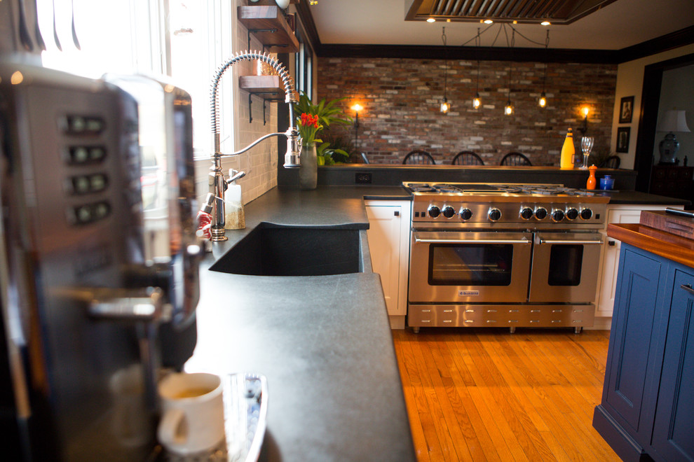 ニューヨークにある高級な広いカントリー風のおしゃれなキッチン (エプロンフロントシンク、落し込みパネル扉のキャビネット、白いキャビネット、木材カウンター、白いキッチンパネル、サブウェイタイルのキッチンパネル、シルバーの調理設備、無垢フローリング、茶色い床、茶色いキッチンカウンター) の写真