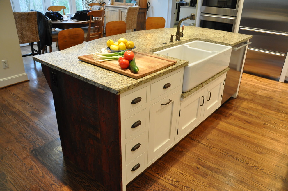 Design ideas for a medium sized traditional galley enclosed kitchen in Louisville with a belfast sink, shaker cabinets, white cabinets, wood worktops, white splashback, ceramic splashback, stainless steel appliances, medium hardwood flooring and an island.