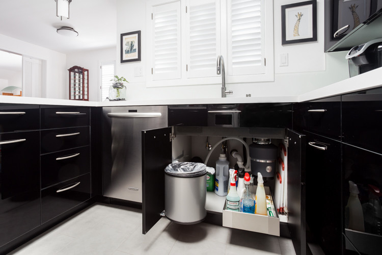 Idéer för ett modernt u-kök, med en undermonterad diskho, släta luckor, svarta skåp, vitt stänkskydd, glaspanel som stänkskydd, rostfria vitvaror och en halv köksö
