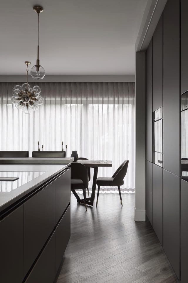 Bild på ett mellanstort funkis grå grått kök, med en integrerad diskho, släta luckor, grå skåp, bänkskiva i kvartsit, stänkskydd med metallisk yta, spegel som stänkskydd, färgglada vitvaror, laminatgolv, en köksö och grått golv