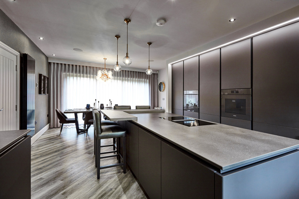 Modern inredning av ett mellanstort grå grått kök, med en undermonterad diskho, släta luckor, grå skåp, bänkskiva i kvartsit, flerfärgad stänkskydd, spegel som stänkskydd, färgglada vitvaror, laminatgolv, en köksö och beiget golv