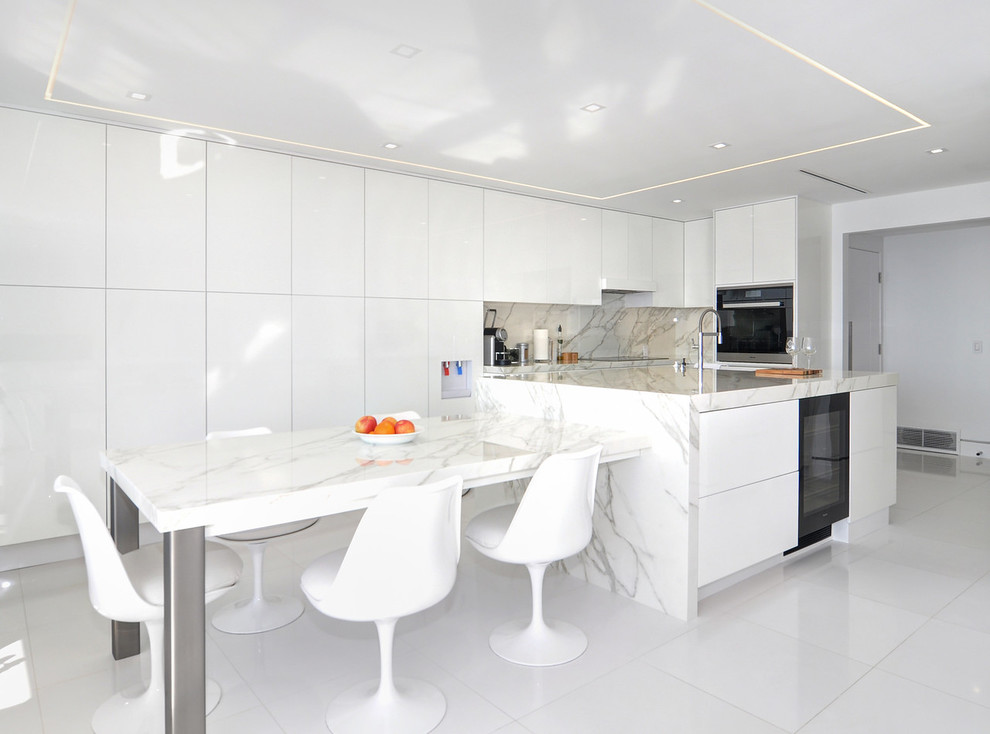 Zweizeilige Moderne Wohnküche mit flächenbündigen Schrankfronten, weißen Schränken, schwarzen Elektrogeräten, Kücheninsel und weißem Boden in Orange County