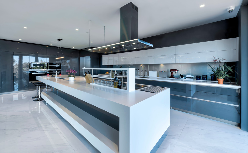 Example of a huge trendy l-shaped porcelain tile and white floor eat-in kitchen design in Nice with flat-panel cabinets, gray cabinets, solid surface countertops, blue backsplash, stainless steel appliances, an island, white countertops, an undermount sink and glass sheet backsplash