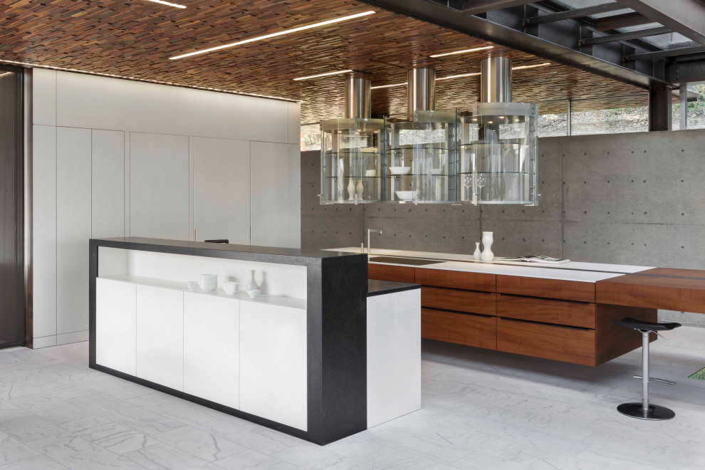 Inspiration for an expansive contemporary l-shaped kitchen in San Francisco with a submerged sink, flat-panel cabinets, white cabinets, integrated appliances, multiple islands, grey floors and white worktops.