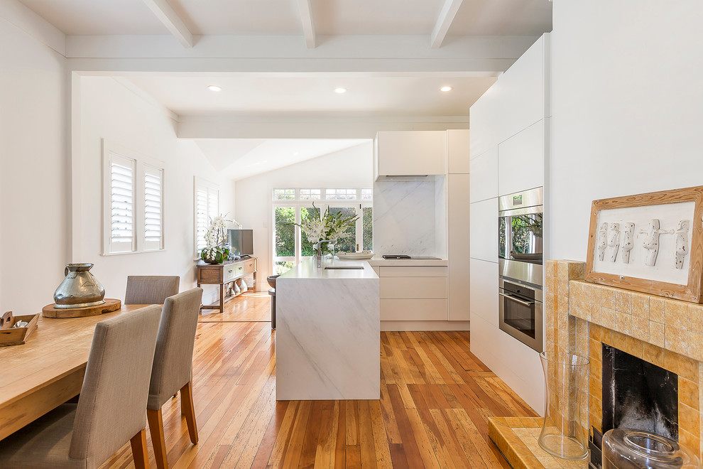Design ideas for a small modern l-shaped open plan kitchen in Auckland with a submerged sink, flat-panel cabinets, white cabinets, marble worktops, white splashback, marble splashback, stainless steel appliances, no island and white worktops.