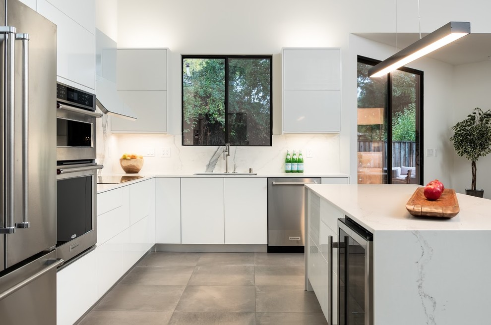 Moderne Küche in L-Form mit Quarzwerkstein-Arbeitsplatte, Rückwand aus Stein und Kücheninsel in Sonstige