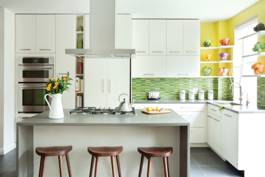 Photo of a medium sized modern l-shaped kitchen/diner in Houston with a built-in sink, flat-panel cabinets, white cabinets, granite worktops, green splashback, matchstick tiled splashback, stainless steel appliances, ceramic flooring and an island.