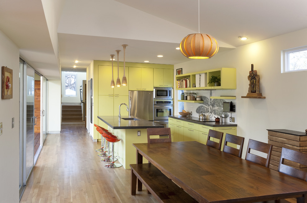 Источник вдохновения для домашнего уюта: узкая кухня в современном стиле с техникой из нержавеющей стали, столешницей из бетона, обеденным столом, врезной мойкой, плоскими фасадами и зелеными фасадами