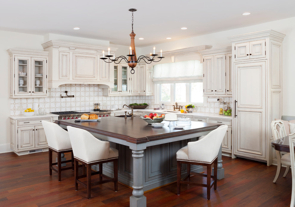Example of a huge classic l-shaped dark wood floor eat-in kitchen design in DC Metro with an undermount sink, beaded inset cabinets, distressed cabinets, quartzite countertops, white backsplash, mosaic tile backsplash, paneled appliances and an island