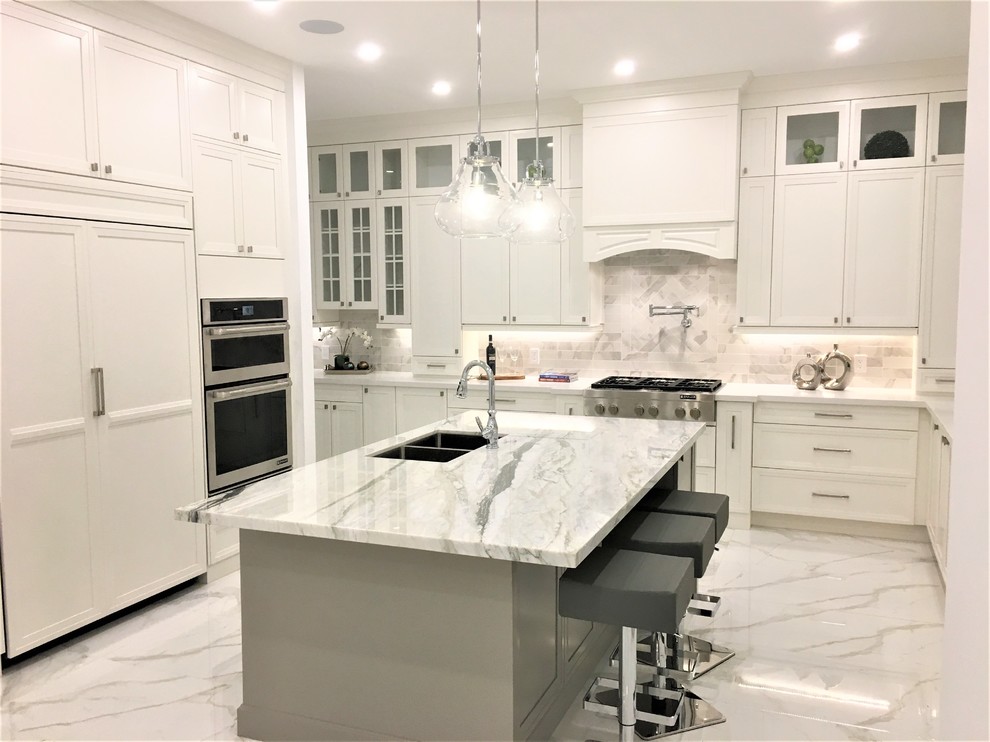 Design ideas for a large classic u-shaped kitchen/diner in Toronto with a submerged sink, recessed-panel cabinets, white cabinets, engineered stone countertops, white splashback, marble splashback, integrated appliances, porcelain flooring, an island, white floors and white worktops.