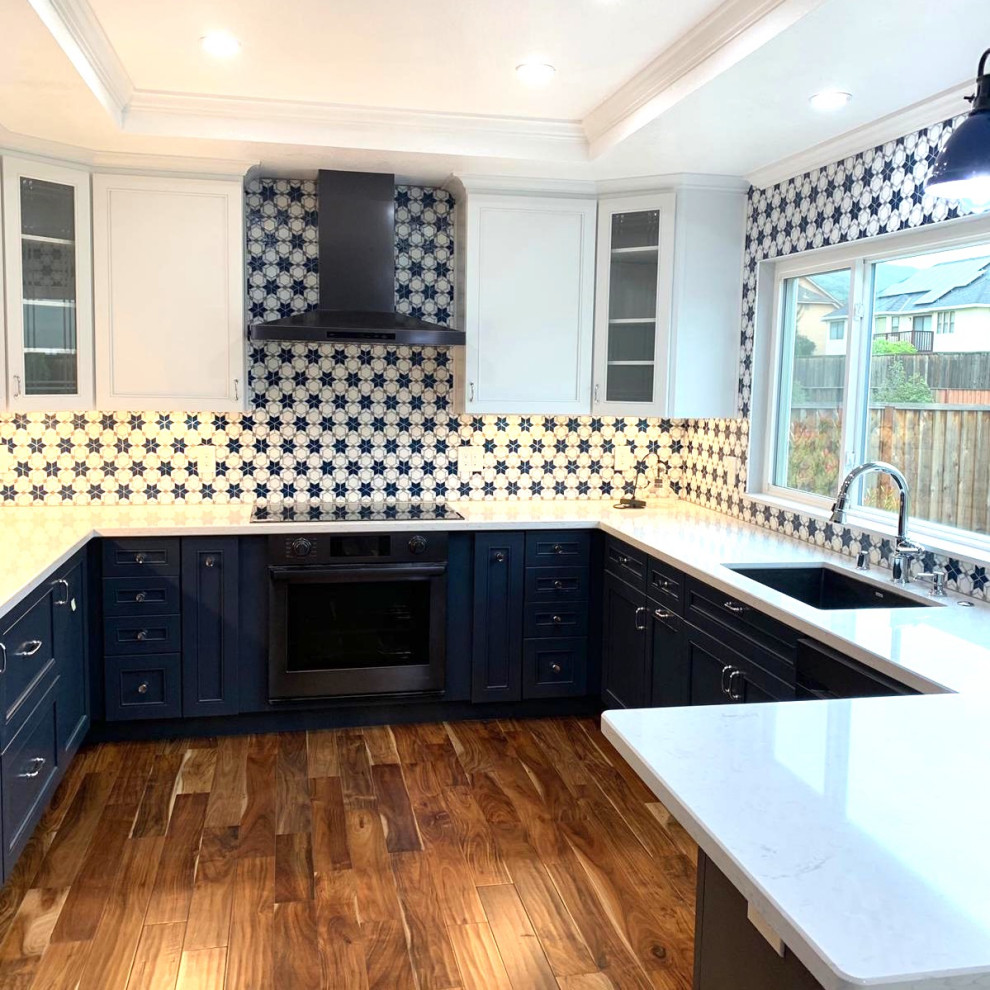 Bild på ett vintage vit vitt kök, med luckor med infälld panel, blå skåp, marmorbänkskiva, blått stänkskydd, stänkskydd i mosaik, mellanmörkt trägolv och brunt golv