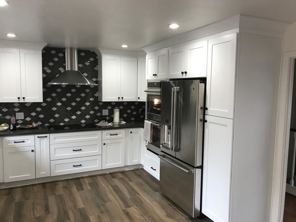 Inspiration for a large contemporary u-shaped kitchen/diner in San Francisco with an integrated sink, beaded cabinets, white cabinets, composite countertops, multi-coloured splashback, ceramic splashback, stainless steel appliances, medium hardwood flooring, no island, beige floors and grey worktops.