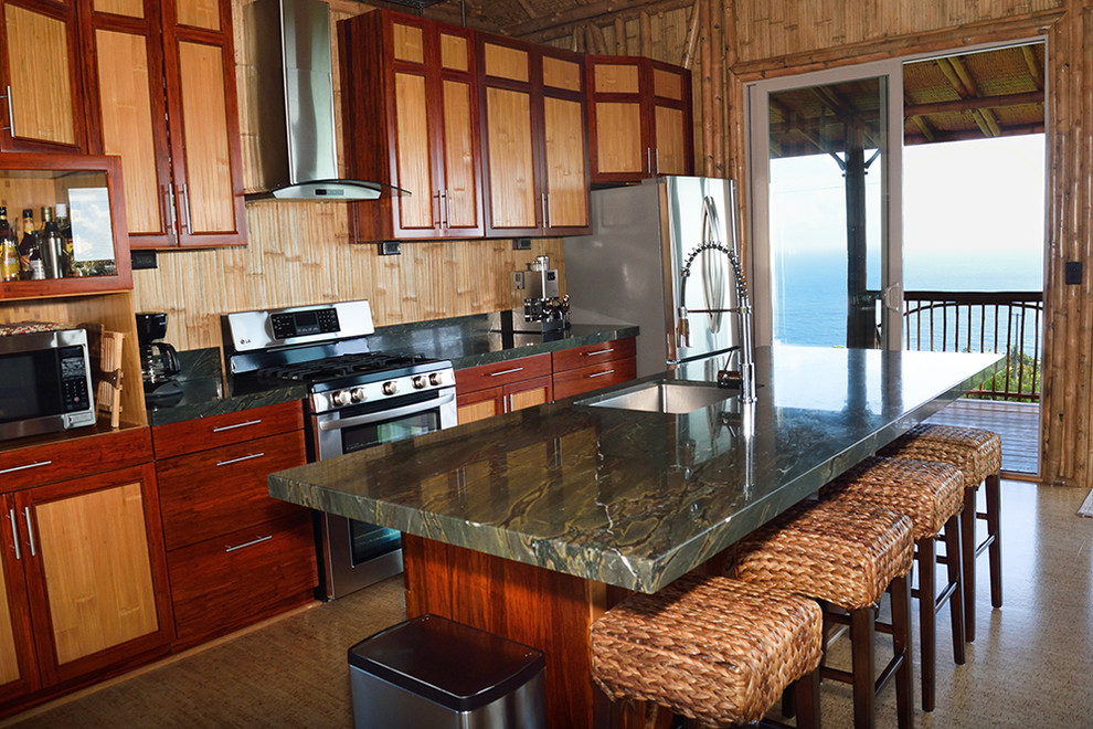 Exempel på ett exotiskt kök, med en undermonterad diskho, luckor med profilerade fronter, skåp i ljust trä, granitbänkskiva, grått stänkskydd, stänkskydd i sten, rostfria vitvaror, korkgolv och en köksö