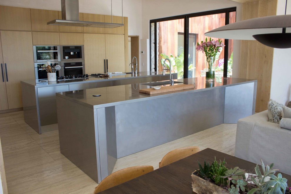 Inspiration for a large modern single-wall beige floor open concept kitchen remodel in Santa Barbara with an integrated sink, flat-panel cabinets, stainless steel cabinets, stainless steel countertops and two islands