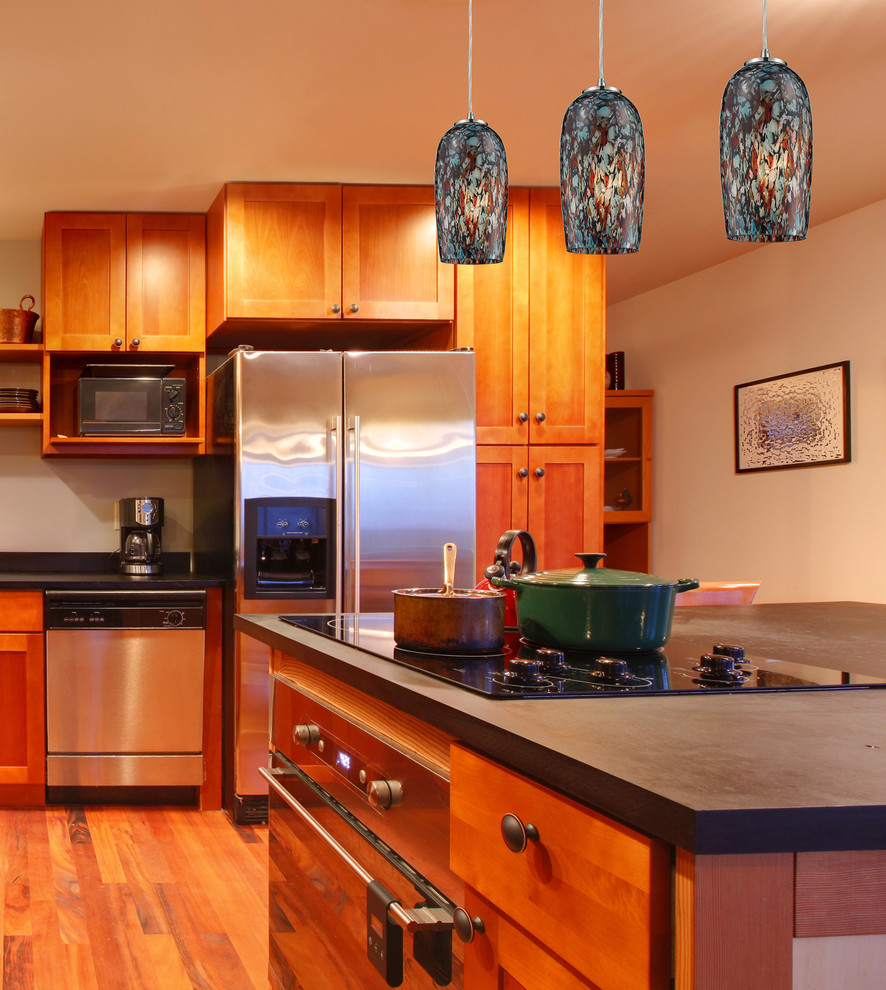 Exempel på ett stort exotiskt kök, med en nedsänkt diskho, luckor med upphöjd panel, skåp i ljust trä, bänkskiva i kalksten, vitt stänkskydd, stänkskydd i keramik, rostfria vitvaror, mellanmörkt trägolv och en köksö