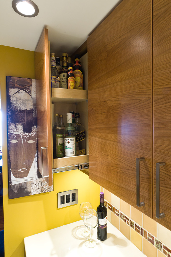 This is an example of a small contemporary u-shaped kitchen/diner in Vancouver with a submerged sink, flat-panel cabinets, brown cabinets, engineered stone countertops, yellow splashback, ceramic splashback, stainless steel appliances, porcelain flooring and no island.