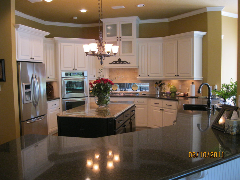 Modern inredning av ett mellanstort kök, med en enkel diskho, luckor med upphöjd panel, vita skåp, granitbänkskiva, flerfärgad stänkskydd, stänkskydd i sten, rostfria vitvaror, klinkergolv i keramik och en köksö