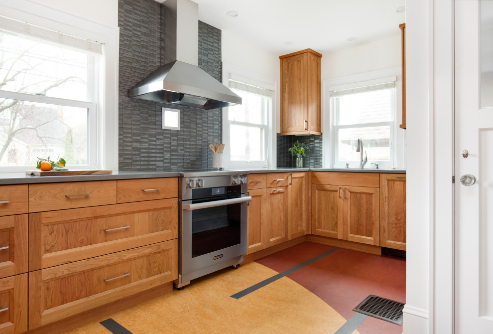 Foto på ett avskilt, litet eklektiskt grå u-kök, med en undermonterad diskho, skåp i shakerstil, skåp i mellenmörkt trä, bänkskiva i kvarts, grått stänkskydd, stänkskydd i glaskakel, rostfria vitvaror, en köksö och flerfärgat golv