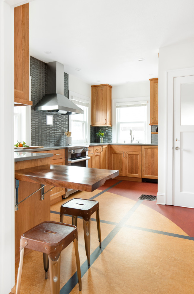 Small eclectic u-shaped multicolored floor enclosed kitchen photo in Portland with an undermount sink, shaker cabinets, medium tone wood cabinets, quartz countertops, gray backsplash, glass tile backsplash, stainless steel appliances, an island and gray countertops