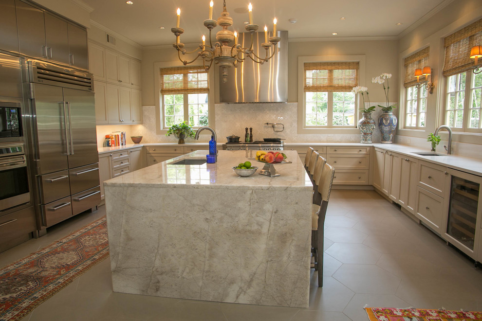 Kitchen - mid-sized transitional u-shaped kitchen idea in New Orleans with an undermount sink, recessed-panel cabinets, beige cabinets, quartzite countertops, beige backsplash, mosaic tile backsplash, stainless steel appliances and an island