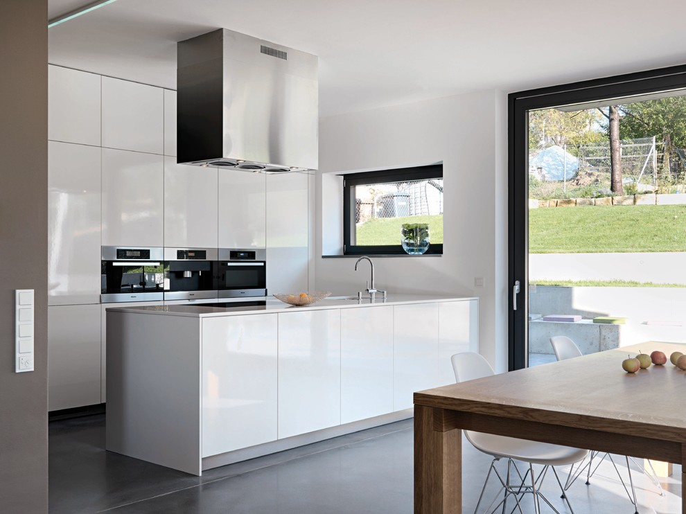Foto de cocina gris y blanca minimalista con electrodomésticos de acero inoxidable y suelo gris